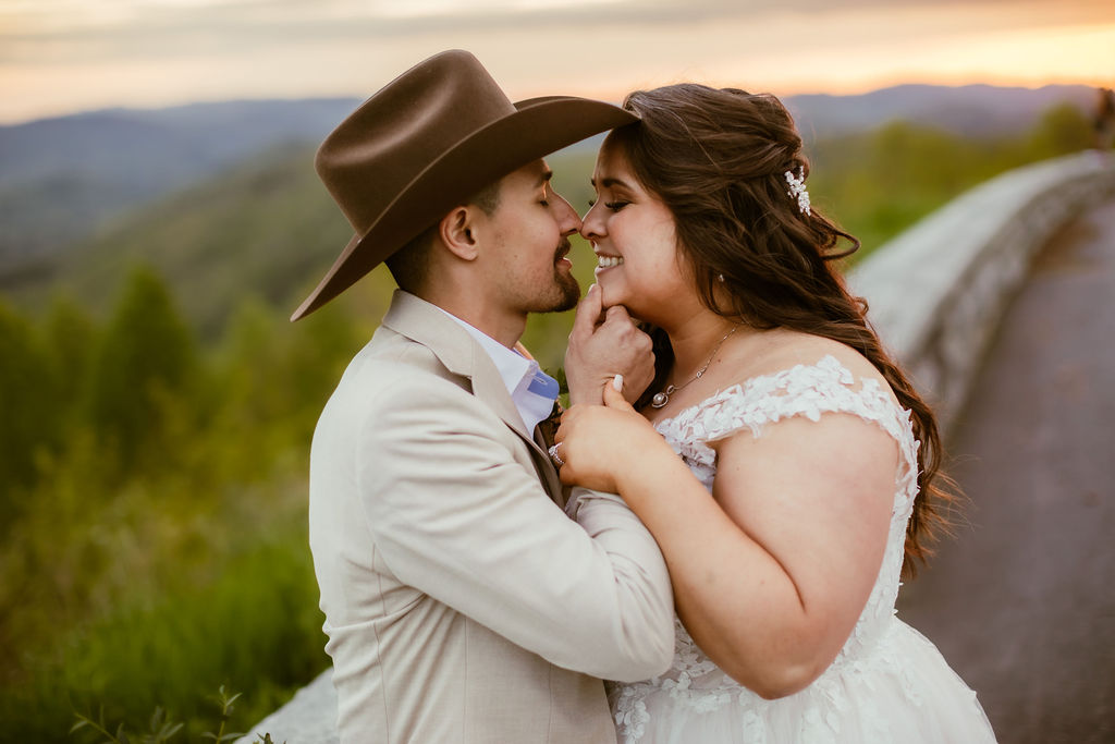 gatlinburg wedding photographers captures groom holding his brides chin and bringing her in for a kiss as the bride giggles at Smoky Mountain elopement