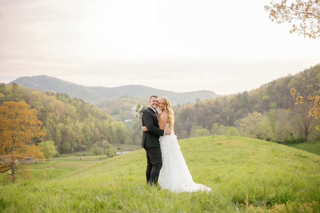 Honeysuckle Hills elopement venue in the smokies with couple embracing in a green field