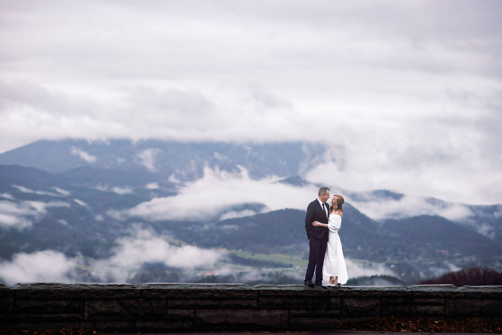 smoky mountain elopement with bride and groom embracing on the parkway with the valley below